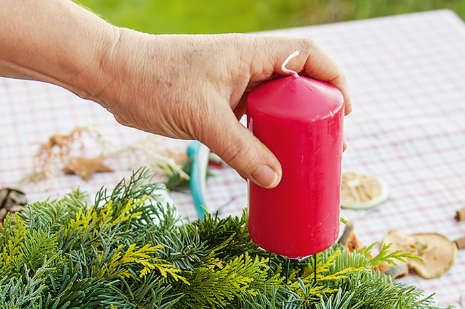 Drei oder vier Drähte pro Kerze werden tief in den Adventskranz gedrückt Für einen sicheren Stand die Kerzen gut andrücken