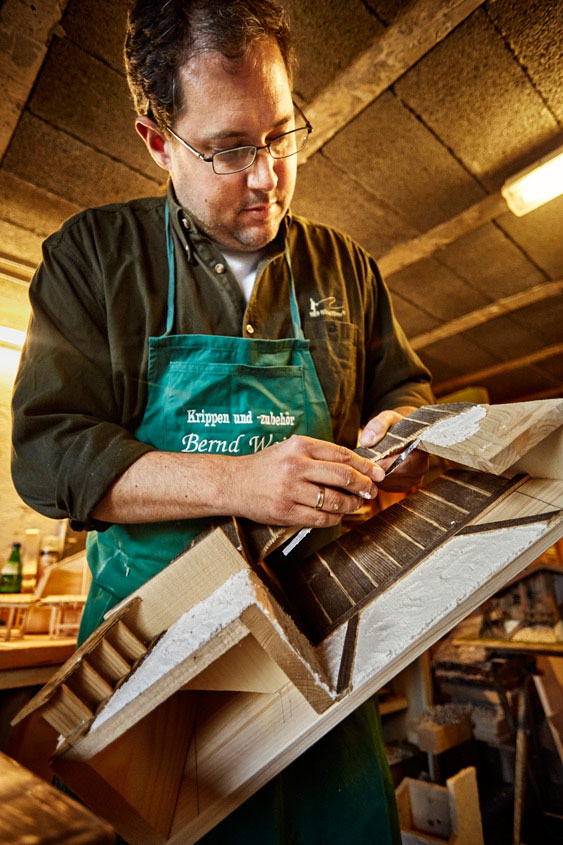 Krippenbauer Bernd Weiß fügt die Bauteile des Hauses zusammen Bernd Weiß beim Zusammenbau des Krippenhauses