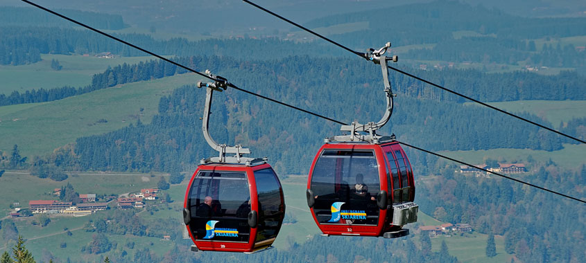 Zwei Seilbahnen bei der Auf- und Abfahrt auf einen Berg im Allgäu