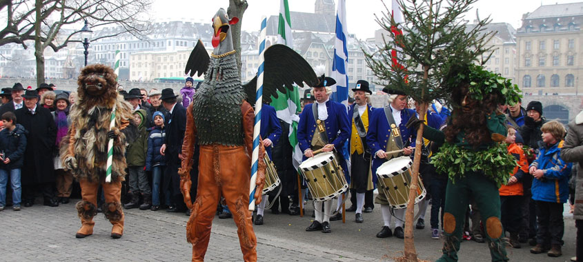 Drei verkleidete Figuren: Löwe, Greif und Baum