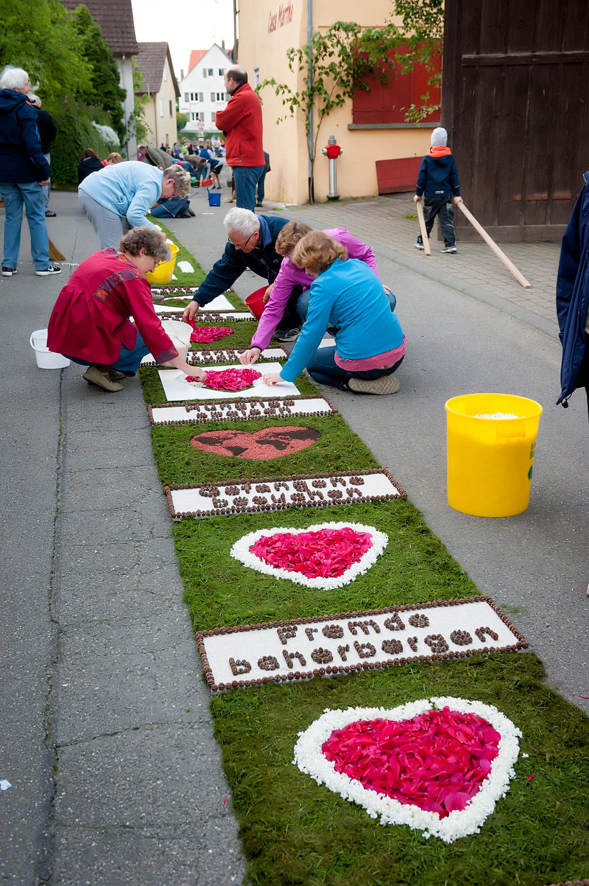Frauen belegen einen Blumenteppich mit Herzen