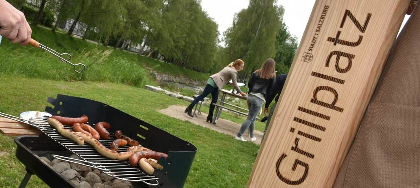 Ein Grill mit Würstchen und ein Pfosten, der den Grillbereich markiert