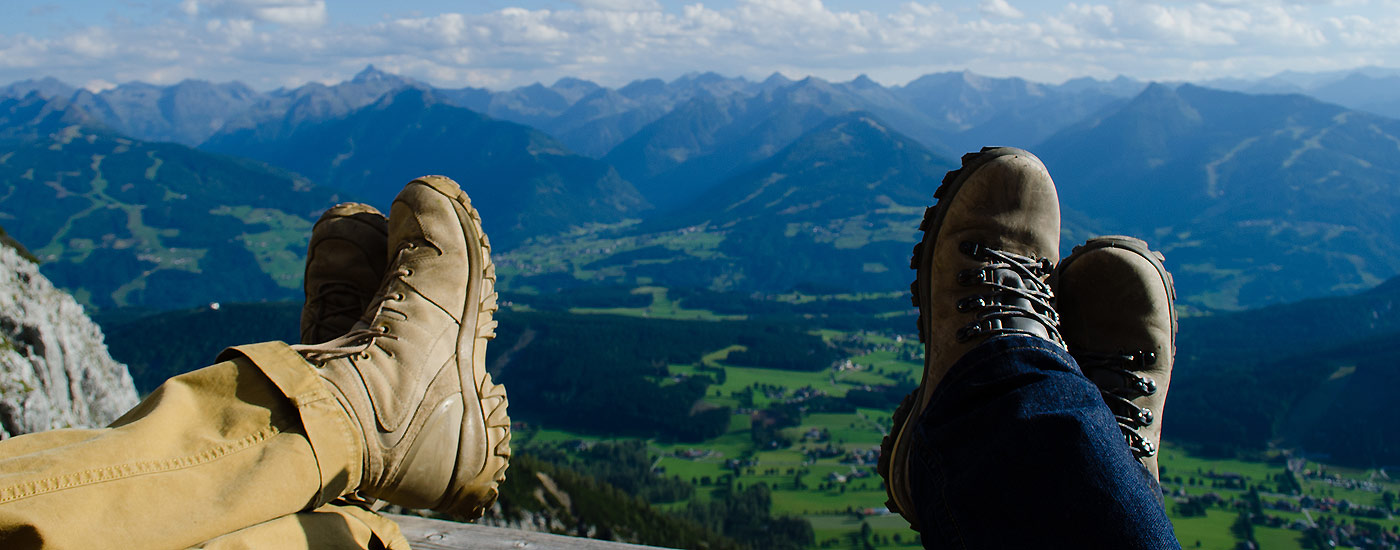 Blasenfrei Wandern: Wanderer haben Füße hochgelegt vor Bergpanorama